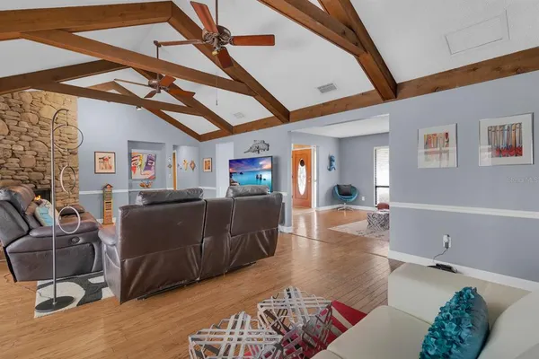 a bedroom with a bed a couch and a flat tv screen on the dresser