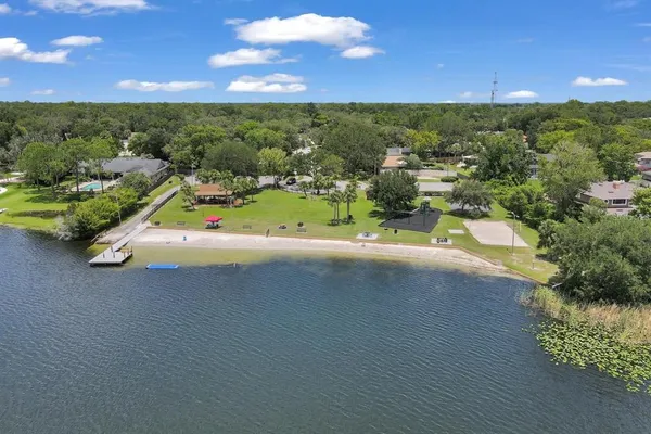 an aerial view of residential houses with outdoor space and trees