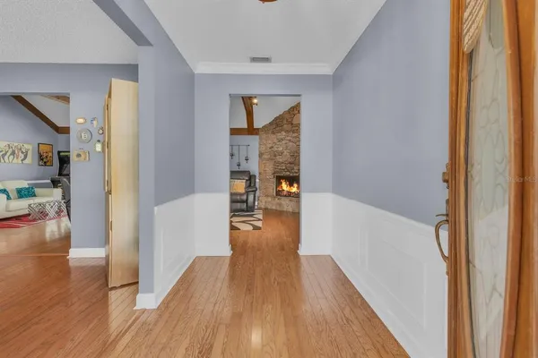 a view of a hallway with wooden floor and a living room