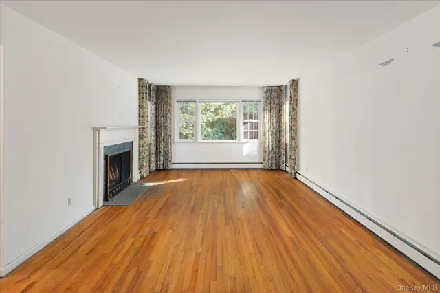 an empty room with wooden floor and a window