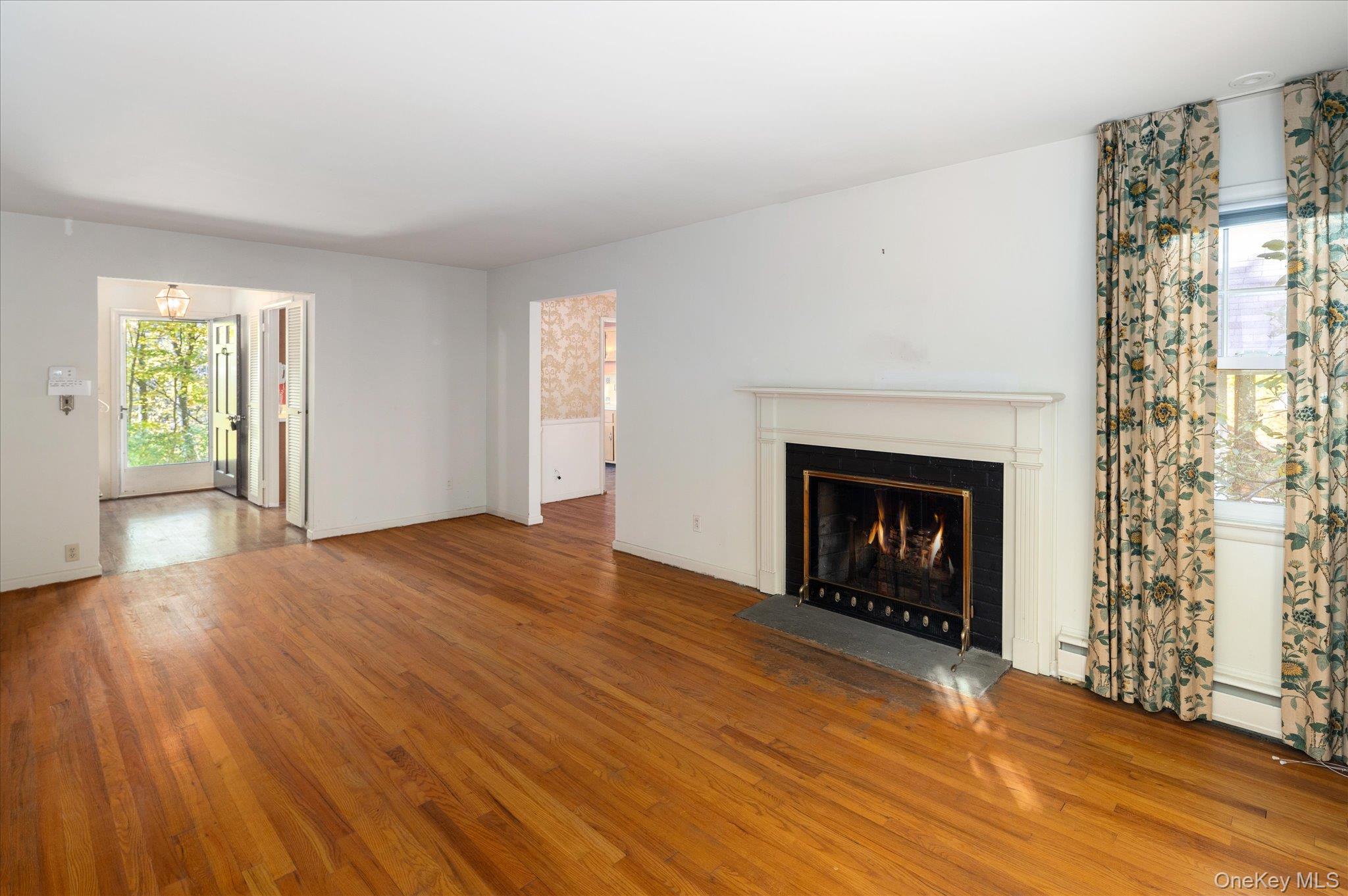 131 Allison Road Katonah, NY 10536 - Photo 14 of 28 a view of an empty room with wooden floor a fireplace and a window