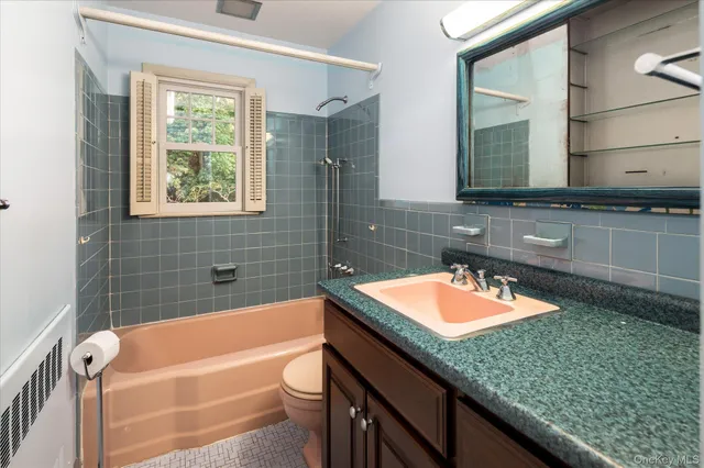a bathroom with a granite countertop tub a sink and a large mirror