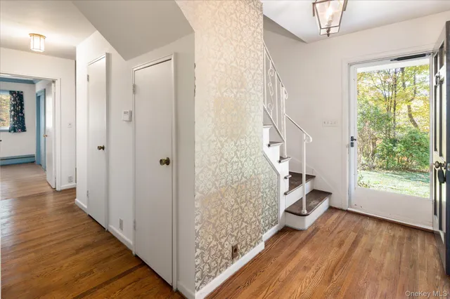 a view of an entryway with wooden floor and door