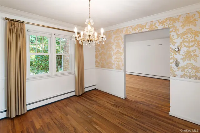 a view of a livingroom with wooden floor and chandelier
