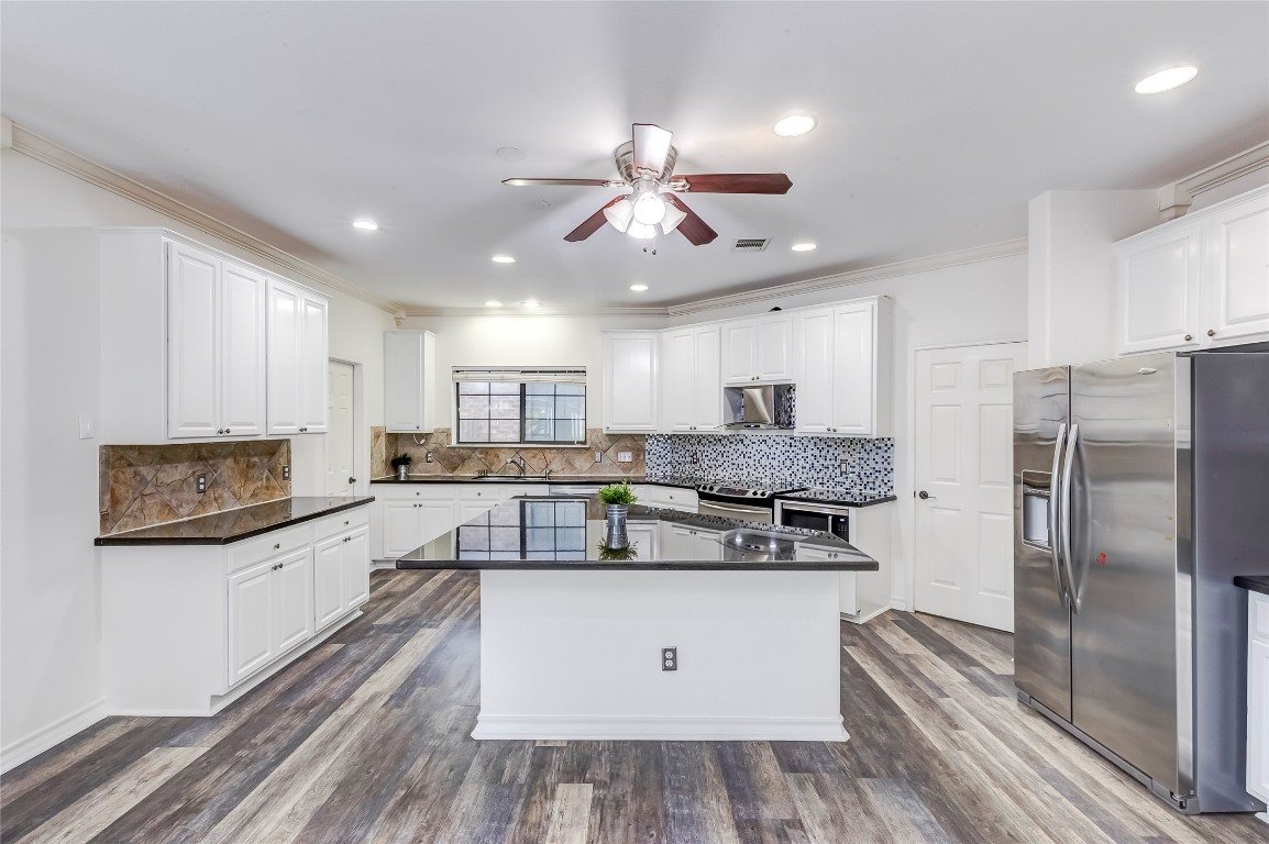 2310 McKendrick Drive Cedar Park, TX 78613 - Photo 11 of 32 a kitchen with stainless steel appliances granite countertop a stove a refrigerator and a sink