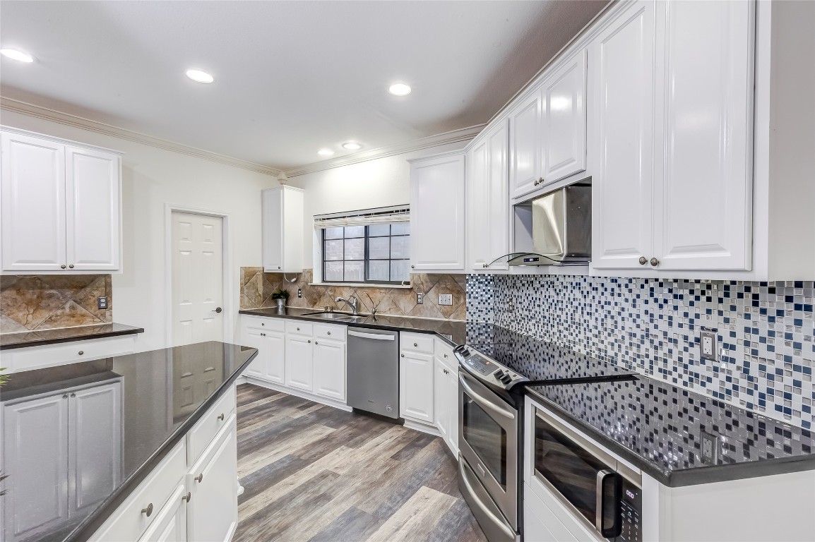 2310 McKendrick Drive Cedar Park, TX 78613 - Photo 13 of 32 a kitchen with granite countertop a sink stove and cabinets
