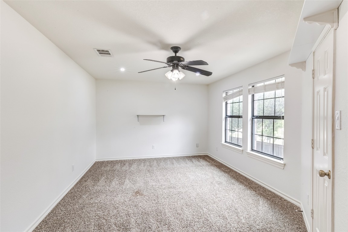 2310 McKendrick Drive Cedar Park, TX 78613 - Photo 24 of 32 an empty room with chandelier fan and windows