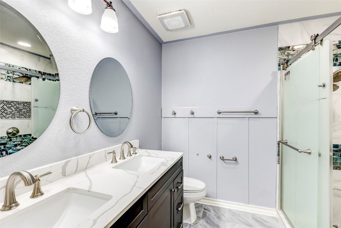 2310 McKendrick Drive Cedar Park, TX 78613 - Photo 25 of 32 a bathroom with a granite countertop sink mirror vanity and toilet