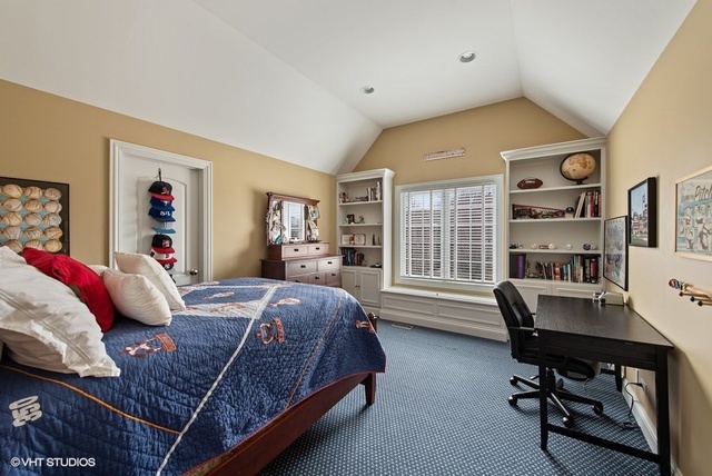 Undisclosed Address Deerfield, IL 60015 - Photo 19 of 34 a bedroom with a bed a desk and book shelfs