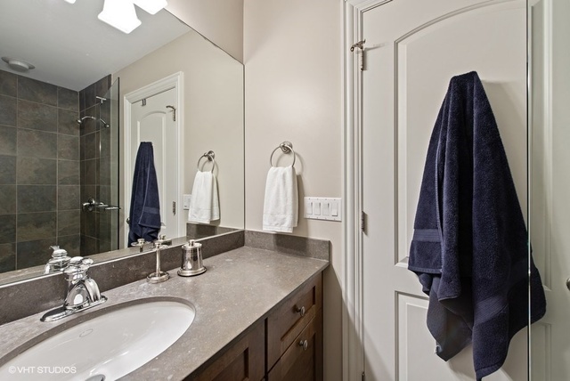 Undisclosed Address Deerfield, IL 60015 - Photo 22 of 34 a bathroom with a double vanity sink and a mirror