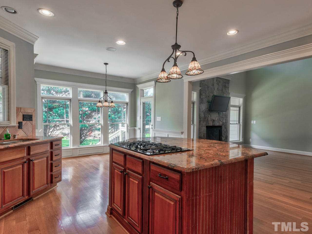 100 Cyprine Court Raleigh, NC 27603 - Photo 8 of 30 a kitchen with stainless steel appliances granite countertop stove a sink a dishwasher a dining table and chairs with wooden floor