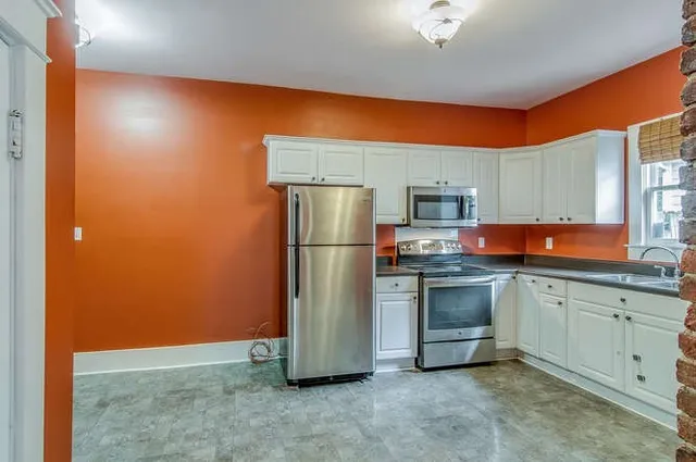a kitchen with stainless steel appliances granite countertop a refrigerator a stove and a sink