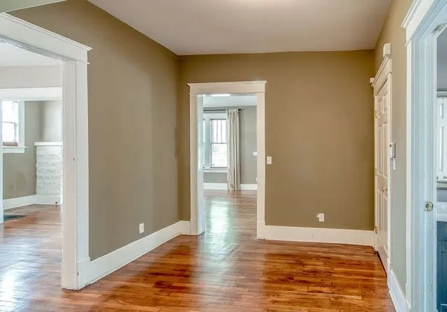 a view of an empty room with wooden floor