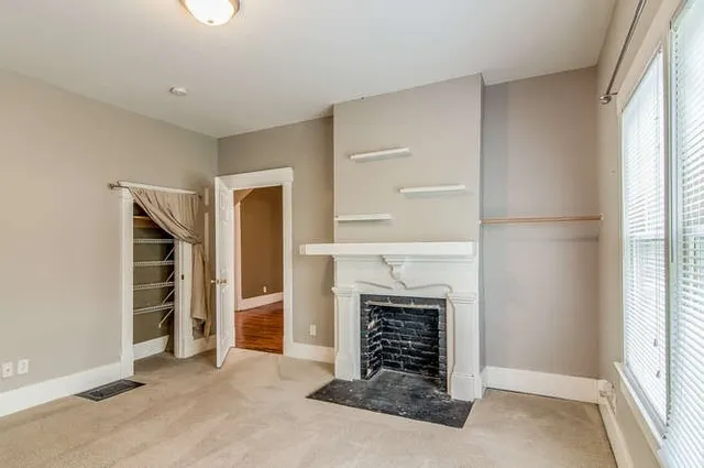 an empty room with fireplace and windows