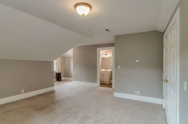 an empty room with closet and mirrors