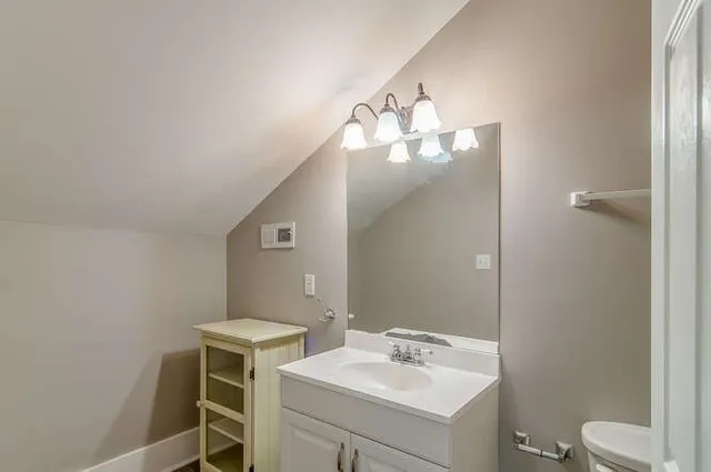 a bathroom with a toilet sink and mirror