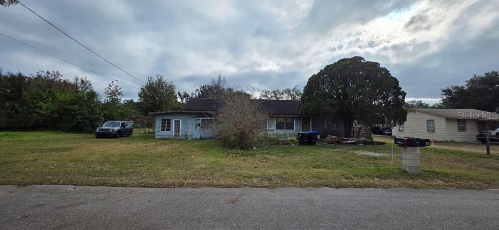 a front view of a house with a garden and tree