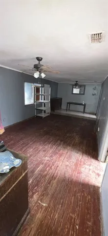 a view of a livingroom with furniture a ceiling fan and window