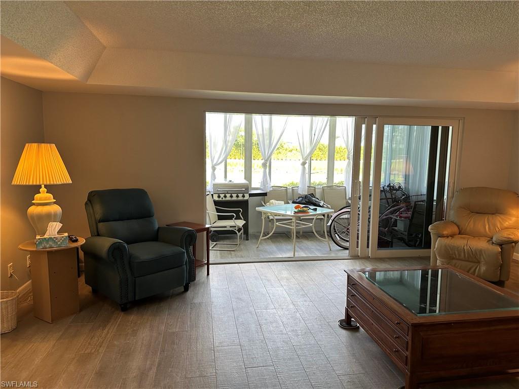 231 Memory Lane, Unit 3 Naples, FL 34112 - Photo 11 of 27 a living room with furniture and a large window