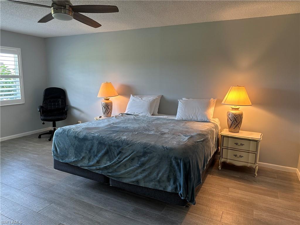 231 Memory Lane, Unit 3 Naples, FL 34112 - Photo 16 of 27 a bedroom with a bed and lamp with window