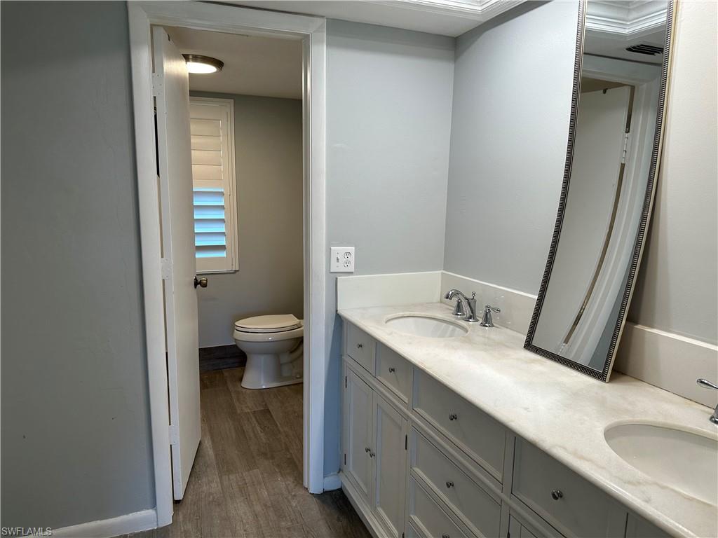231 Memory Lane, Unit 3 Naples, FL 34112 - Photo 18 of 27 a bathroom with a granite countertop sink a toilet and a mirror
