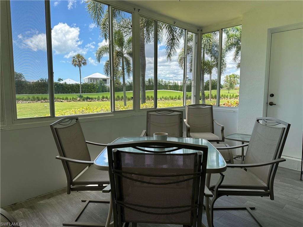 231 Memory Lane, Unit 3 Naples, FL 34112 - Photo 25 of 27 a view of a dining room with furniture large windows and wooden floor