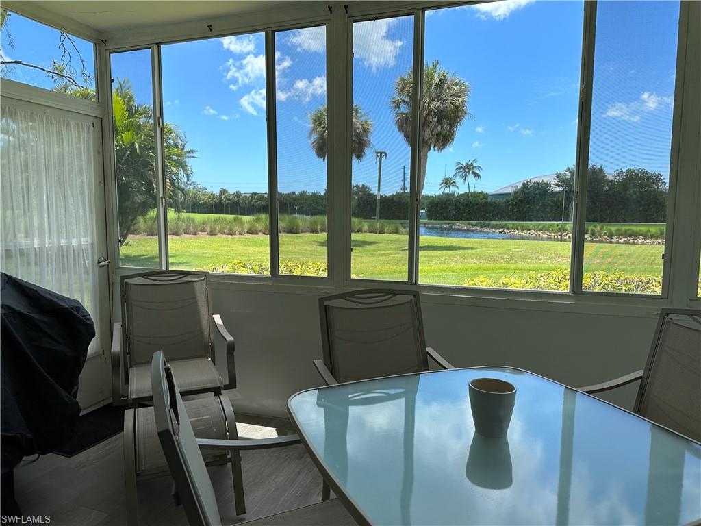 231 Memory Lane, Unit 3 Naples, FL 34112 - Photo 26 of 27 a view of a living room with furniture and a floor to ceiling window