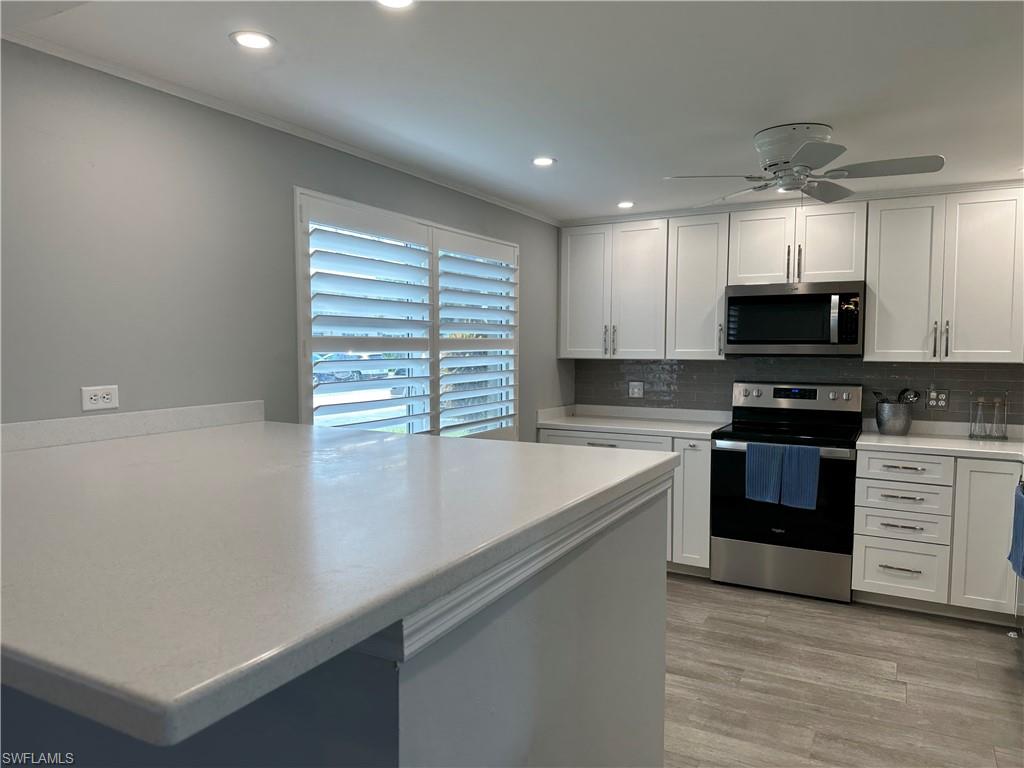 231 Memory Lane, Unit 3 Naples, FL 34112 - Photo 3 of 27 a kitchen with stainless steel appliances a stove sink and microwave