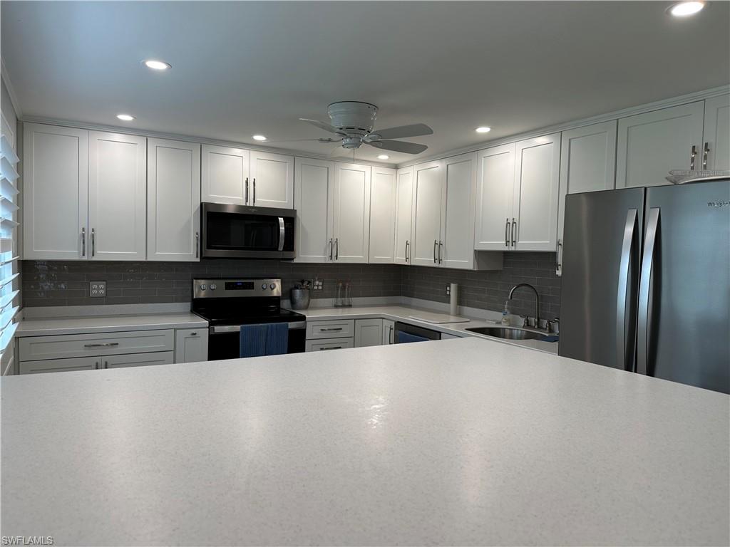 231 Memory Lane, Unit 3 Naples, FL 34112 - Photo 4 of 27 a kitchen with stainless steel appliances a refrigerator and a sink
