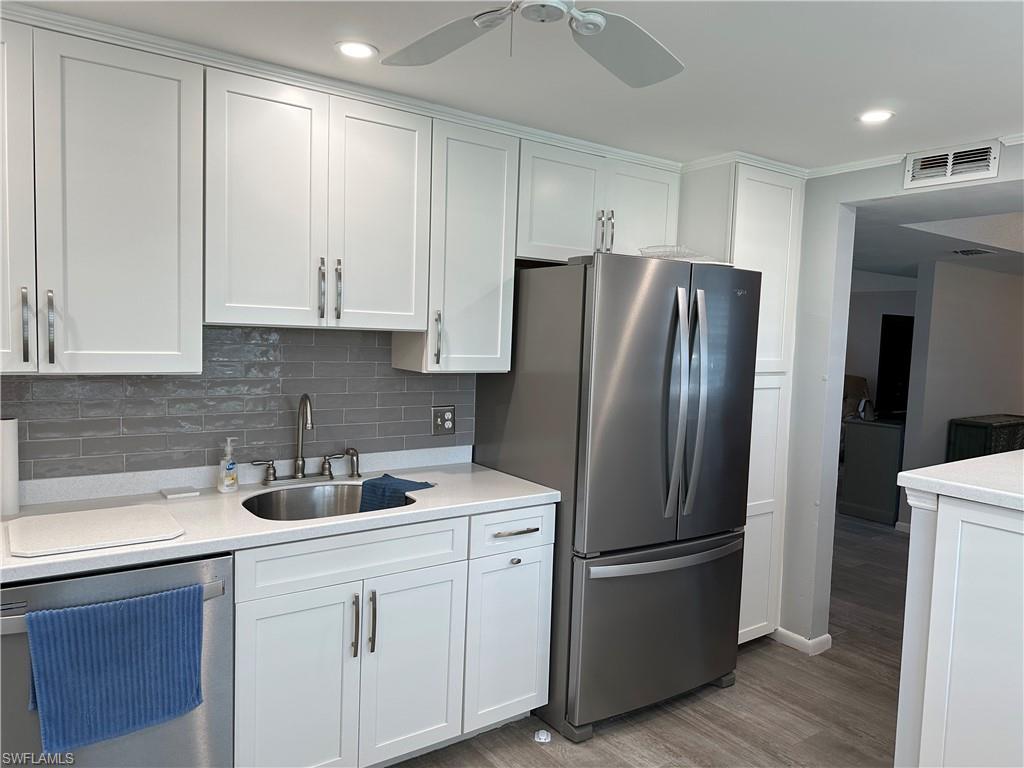 231 Memory Lane, Unit 3 Naples, FL 34112 - Photo 5 of 27 a kitchen with stainless steel appliances white cabinets and a refrigerator
