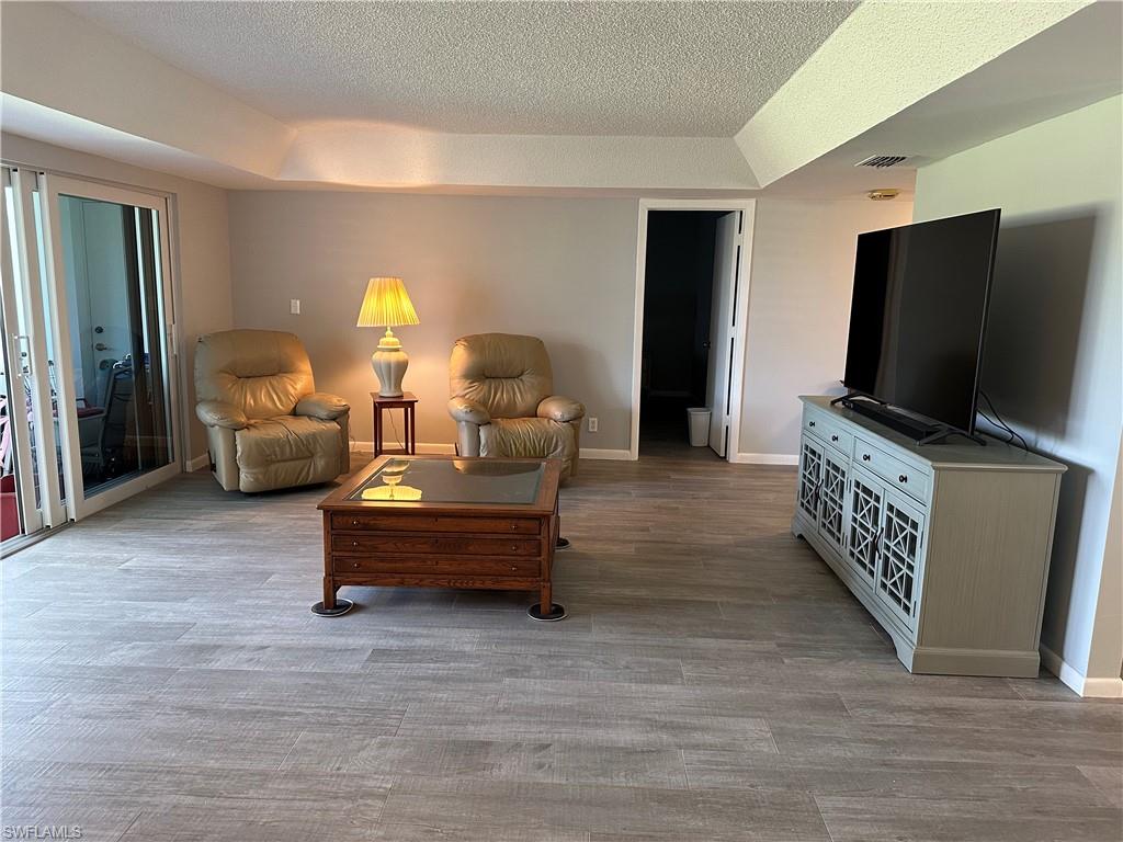 231 Memory Lane, Unit 3 Naples, FL 34112 - Photo 10 of 27 a living room with furniture and a flat screen tv