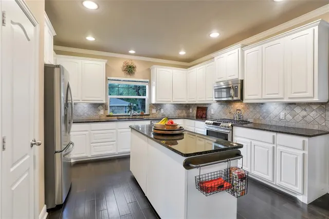 a kitchen with stainless steel appliances a refrigerator sink and cabinets