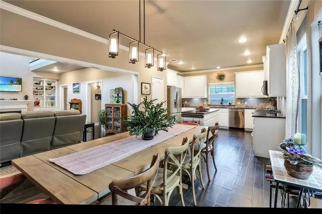 a view of a dining room and livingroom with furniture wooden floor a chandelier