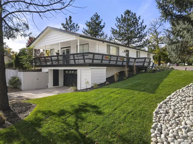 a front view of a house with a garden and deck