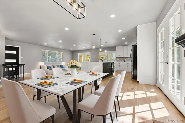 a open dining room with stainless steel appliances kitchen island granite countertop a dining table chairs and window