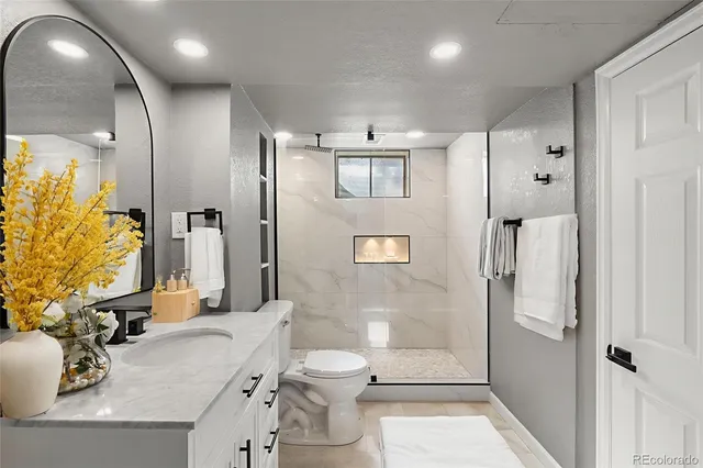 a bathroom with a granite countertop sink toilet and shower