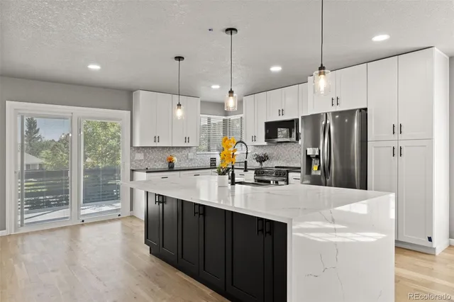 a kitchen with kitchen island white cabinets and stainless steel appliances