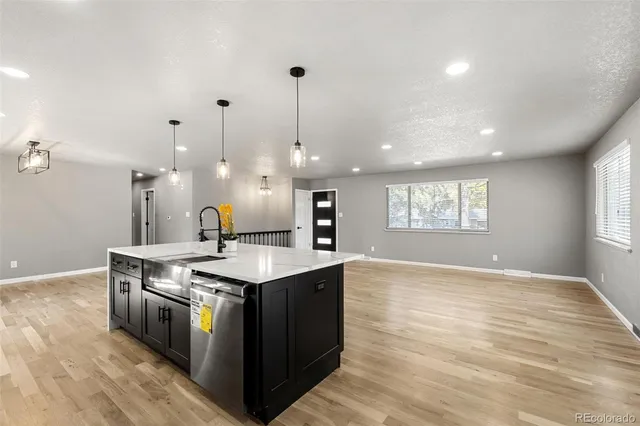 a kitchen with stainless steel appliances granite countertop a sink a stove a refrigerator and a window