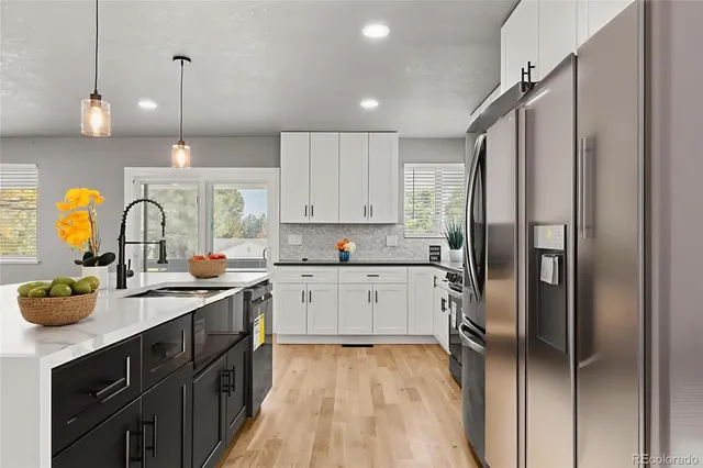 a kitchen with stainless steel appliances granite countertop a sink a stove and refrigerator