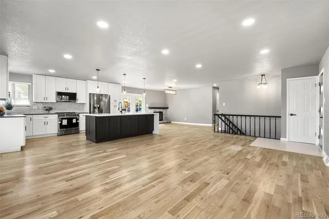 a view of kitchen and kitchen with stainless steel appliances wooden floor