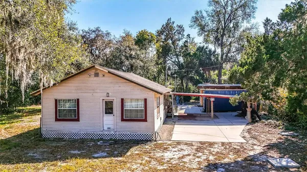 a view of house with yard and sitting area