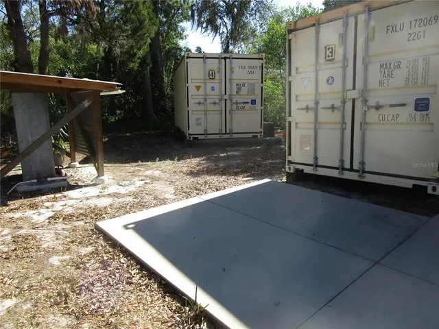 a view of backyard with large tree and wooden fence