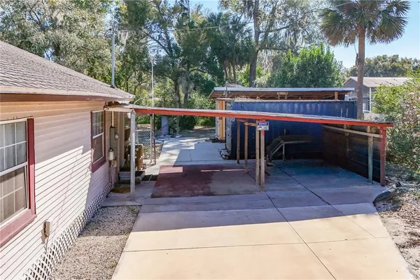 a view of a backyard with a trees and wooden fence