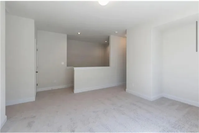 a view of a hallway with wooden floor and stairs