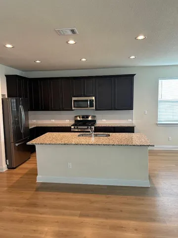 a kitchen with stainless steel appliances granite countertop a stove a sink and a refrigerator