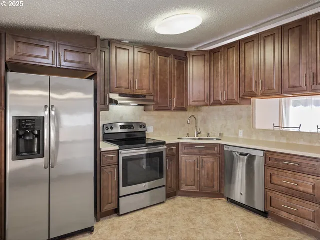 a kitchen with a refrigerator sink and cabinets