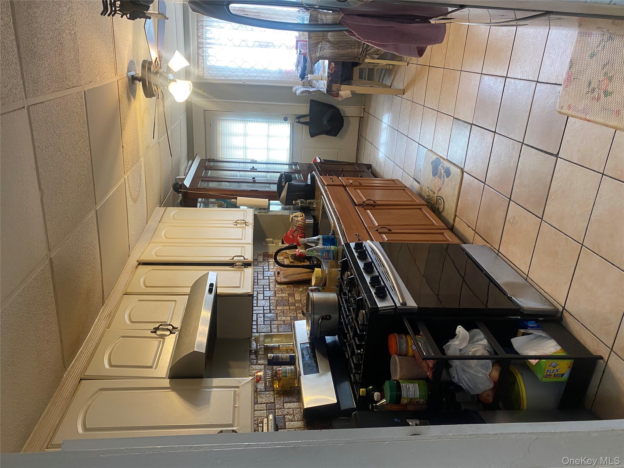 24 Lent Avenue Hempstead, NY 11550 - Photo 4 of 14 a kitchen with stainless steel appliances granite countertop a stove a sink and a refrigerator