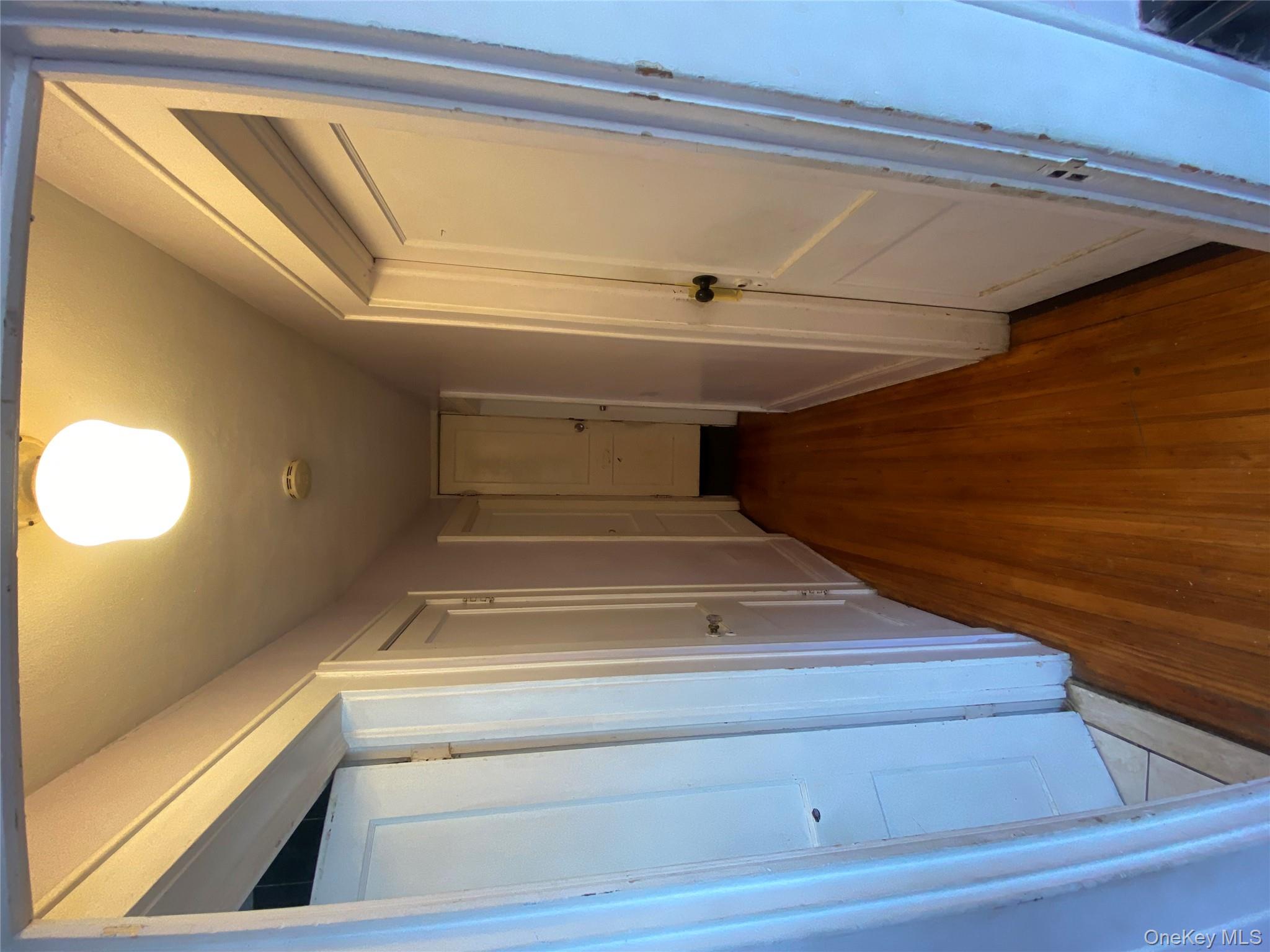 24 Lent Avenue Hempstead, NY 11550 - Photo 7 of 14 a view of a hallway with wooden floor and staircase
