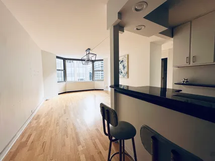 a view of a hallway with wooden floor and chair