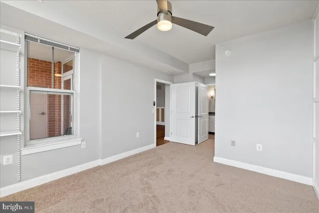 an empty room with windows and closet